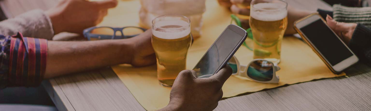 People drinking beer while checking their cellphones